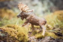 Moose In The Woods. Toy Figurine In Nature