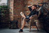 Fototapeta  - The bearded hipster male relaxing in a chair.