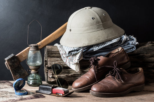still life photography : axe, compass, hunter hat, jeans, lamp, leather shoe, map, pocket knife, shi