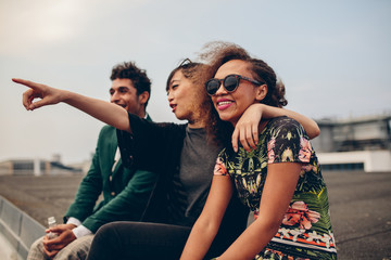 Friends sitting on rooftop and enjoying the view