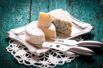 Composition of cheese, berries, bottles and glasses of wine on a wooden table