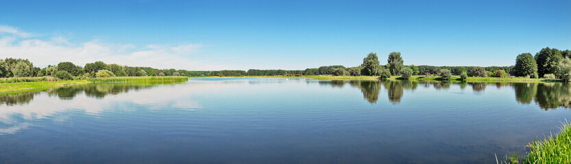 see vom seeufer aus bei blauem himmel - fischteich panorama