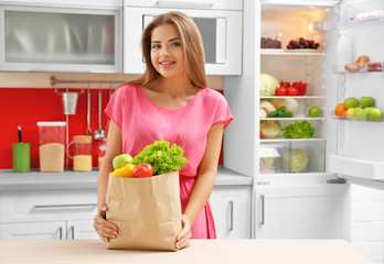 Beautiful girl with vegetables in kitchen. Healthy food concept