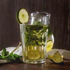 Wall Mural - Mint iced tea with lime in the glass. Dark background.