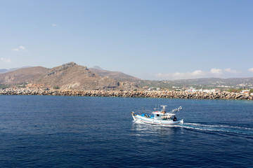 Wall Mural - fishing boat in the sea on a background of mountains