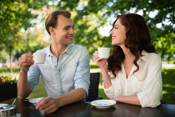 Couple drinking a cappuccino while sitting outdoors