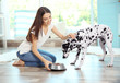 © Africa Studio - Female owner feeding her dalmatian dog