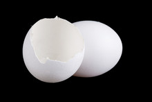 Egg And Empty Eggshell Isolated On Black Background