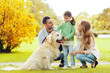 © Syda Productions - happy family with labrador retriever dog in park