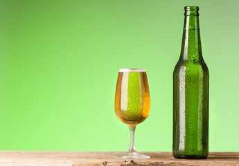 Beer bottle and glass with water drops