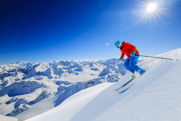 Wall Mural - Skier skiing downhill in high mountains in fresh powder snow. Snow mountain range in background. Mt Fort Peak Alps region Switzerland.