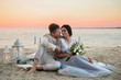 © ronedya - Young couple in love outdoor. Young bride and groom posing at sunset on the beach. young couple on the beach. young couple relaxing at sunset. young couple relaxing on the beach