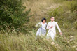 © ronedya - Young couple in love outdoor. Elegant bride and groom posing together outdoors on a wedding day. bride and groom in the Park. young couple in the woods. young couple in the grass. couple walking