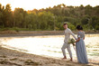© ronedya - Young couple in love outdoor. Young bride and groom posing at sunset on the beach. young couple on the beach. young couple relaxing at sunset. young couple relaxing on the beach
