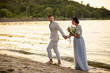 © ronedya - Young couple in love outdoor. Young bride and groom posing at sunset on the beach. young couple on the beach. young couple relaxing at sunset. young couple relaxing on the beach