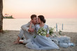 © ronedya - Young couple in love outdoor. Young bride and groom posing at sunset on the beach. young couple on the beach. young couple relaxing at sunset. young couple relaxing on the beach