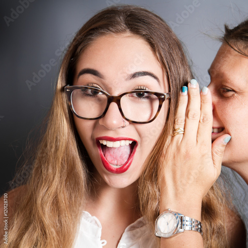 Fotografering donna sorpresa per un segreto detto all'orecchio