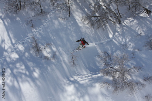 Obraz na plátně Snowboarder Rides Down the Snowy Mountain Terrain at the Ski Resort at Nevados D