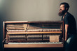 © Volodymyr - bearded man trying to move wooden piano