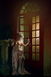 Half-naked Victorian lady. Young woman in eighteenth century image posing in vintage interior
