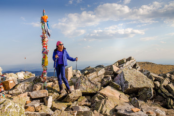 Wall Mural - Female is trekking in Mountains among field of stones and rocks.