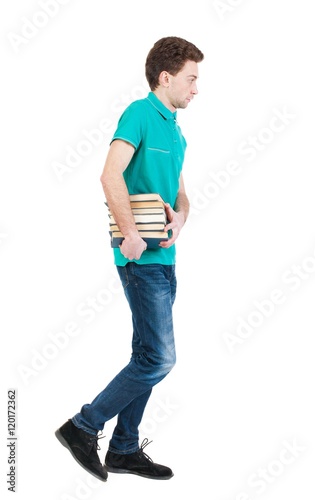 Back View Of Going Handsome Man Carries A Stack Of Books Walking Young Guy Rear View