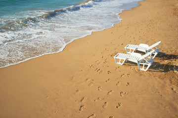 two loungers on the beach near the shore