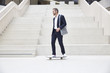 © Westend61 - Businessman riding skateboard at staircase