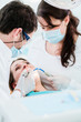 © Kzenon - Dentist treating woman patient with drill