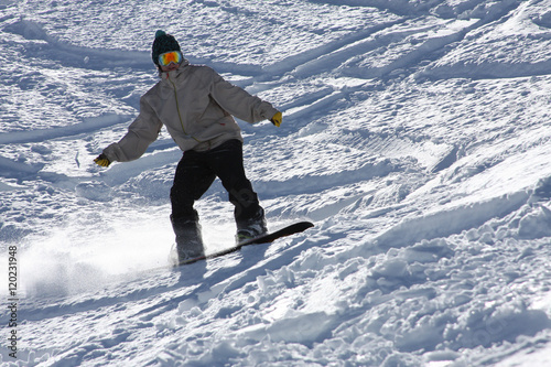 Fotografie, Obraz Close Up on a Snowboarder Carving Turns With His Board in the Snow
