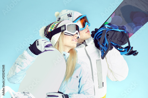 Zdjęcie XXL Młodzi ludzie nosząc okulary narciarskie i trzymając deski snowboardowe patrząc na coś