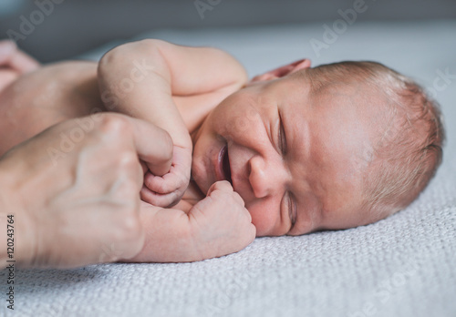 Cuadros en Lienzo Sweet smiling newborn baby lying in bed.