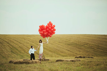 charming woman holds many red balloons