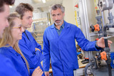 Fototapeta  - Teacher explaining machinery to apprentices