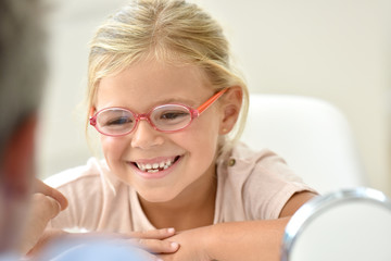 Little girl at the optician trying different eyeglasses