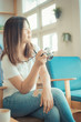 © themorningglory - Beautiful young asian girl resting on sofa with camera in a cafe
