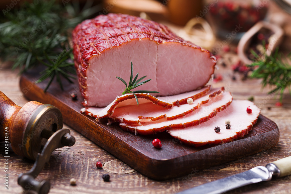 Delicious smoked ham on a wooden board with spices. - obrazy, fototapety, plakaty 
