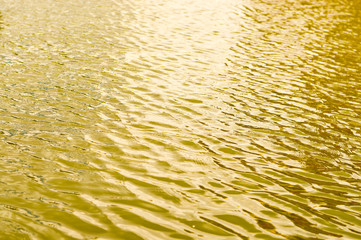 Golden water ripple as sunset in summer