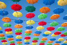 Multicolored Umbrellas Row In Blue Sky