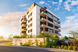 Fototapeta Miasta - New modern block of flats in green area with blue sky