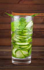 Poster - Refreshing cocktail of cucumber and mint leaves on a wooden background