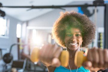 Happy healthy young African American woman working out in a gym