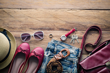 clothing and accesories for women, placed on a wooden floor.