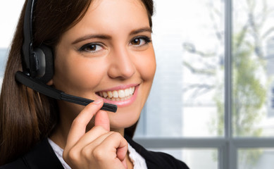 Wall Mural - Female customer support operator with headset and smiling 