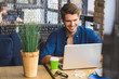 © Yakobchuk Olena - young freelancer in front of a laptop smiling with teeth