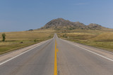 Fototapeta Przestrzenne - Bear Butte Highway / A highway leading to a butte.