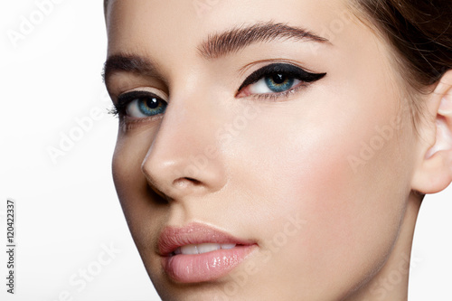 Fotografía Chica con piel limpia y maquillaje natural con flechas negras en los ojos mirand