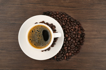 Canvas Print - Cup of coffee with beans on wooden background