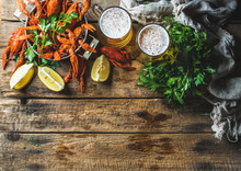 Two Pints Of Wheat Beer And Boiled Crayfish With Lemon And Parsley Over Old Wooden Rustic Background, Top View, Copy Space