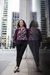© Astrakan Images - Confident businesswoman standing on sidewalk by glass window